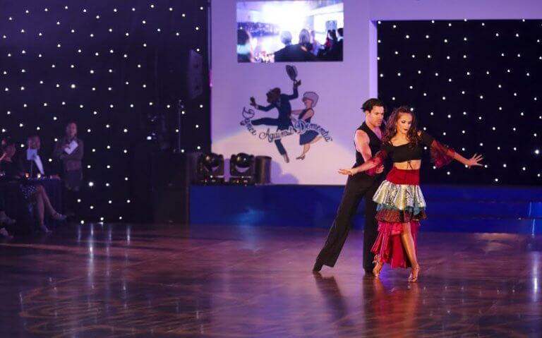 Ballroom dancers performing on Harlequin dance floor